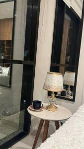 ein Tisch mit einer Lampe neben einem Bett in der Unterkunft monoambiente completo y central in Santa Cruz de la Sierra