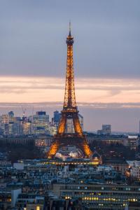 a view of the eiffel tower at night at Paris luxury Apartment with Eiffel Tower View, 1 min metro, parking in Paris