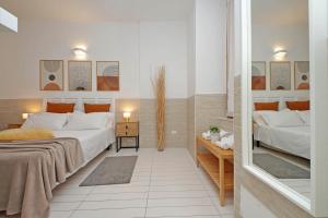 1 dormitorio con 2 camas y espejo en Opera Inn Suites - Rooms and Apartments, en Roma