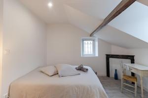 a white bedroom with a bed and a desk at D'am Chic Nomade Appartement bleu in Périgueux