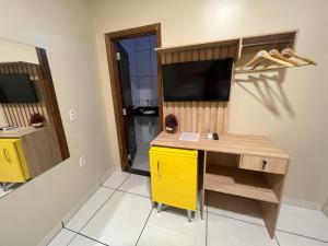 um quarto com uma secretária e um armário amarelo em POUSADA AMORIM em Santo Amaro