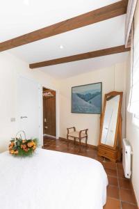 1 dormitorio con cama blanca y espejo en Casa Costaneira, en Boiro