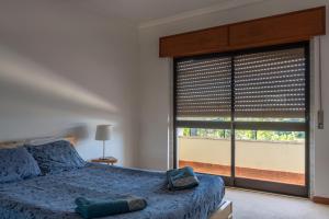 een slaapkamer met een bed en een groot raam bij Global Guest Sintra in Sintra