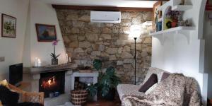 Casa Costaneira في بويرو: غرفة معيشة بها موقد وحائط حجري
