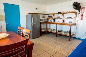 cocina con nevera, mesa, mesa y sillas en Beachfront Suite 5 Cacique, en Vieques