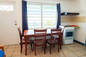 een keuken met een tafel en stoelen en een raam bij Beachfront Suite 5 Cacique in Vieques