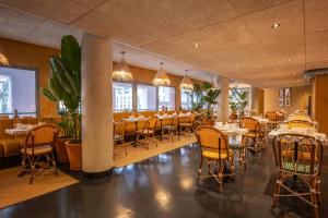 ein Restaurant mit Tischen und Stühlen in einem Zimmer in der Unterkunft Kopster Hotel Paris Porte de Versailles in Paris