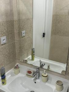 Apartment for tourists في سمرقند: حوض الحمام مع مرآة كبيرة فوقه