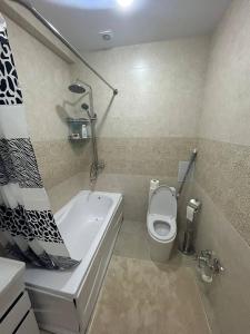 Apartment for tourists في سمرقند: حمام مع حوض استحمام ومرحاض