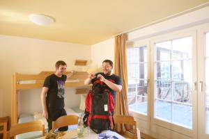 two men are standing in a room taking a picture at Jugendherberge Lübeck Altstadt in Lübeck