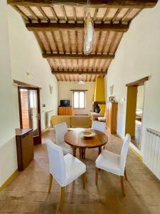 sala de estar con mesa y sillas blancas en Casale dell'Assiolo Bed and Breakfast, en Petrignano sul Lago