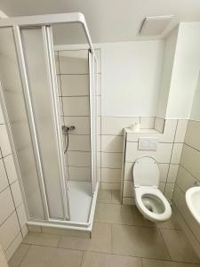 a white bathroom with a shower and a toilet at Pension Sonnenschein in Halle an der Saale