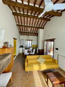 ein Wohnzimmer mit einem gelben Sofa und einem Tisch in der Unterkunft Casale dell'Assiolo Bed and Breakfast in Petrignano sul Lago