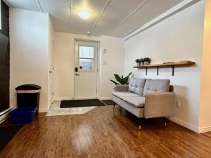 a living room with a couch and a door at Beau studio 2 chambres in Val-dʼOr
