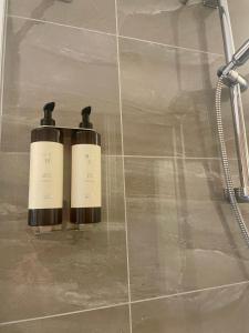 two bottles of shampoo sitting on a tiled bathroom floor at Fata Morgana in Cochem
