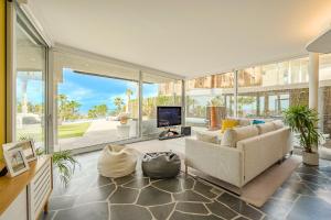 a living room with a couch and a tv at Stunning Sunsets Abama in Playa de San Juan