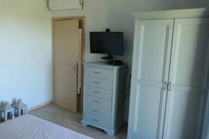 una camera da letto con un comò con una televisione di Villa Supramonte luxury villa IUN R7796 a Marazzino