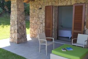 une terrasse avec 2 chaises et une table verte dans l'établissement Villa Supramonte luxury villa IUN R7796, à Marazzino