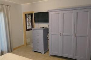 een slaapkamer met een dressoir en een grote witte kast bij Villa Supramonte luxury villa IUN R7796 in Marazzino