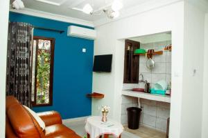 a living room with blue walls and a chair and a table at ALICIA HÔTEL in Yaoundé