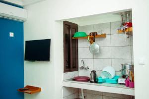 uma cozinha com um balcão com um lavatório e uma televisão em ALICIA HÔTEL em Iaundé