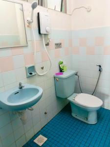 een badkamer met een blauw toilet en een wastafel bij Studio Beach View Teluk Kemang in Port Dickson