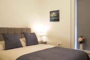 um quarto com uma cama com duas almofadas azuis em Blue Door Apartments em Newcastle