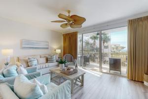 Una sala de estar con un sofá y un ventilador de techo. en High Pointe 2221, en Inlet Beach