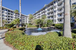 een groot appartementencomplex met een vijver ervoor bij Sea Crest 2405 in Hilton Head Island