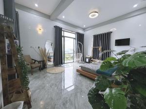uma sala de estar com uma cama e algumas plantas em Nick’s House - Homestay Đảo Phú Quý em Cu Lao Thu