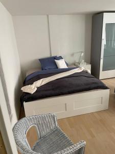 a bedroom with a bed and a chair and a mirror at 1.5 Zimmer Wohnung Altstadt Zug in Zug