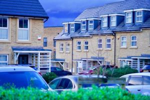 a row of houses with cars parked in a parking lot at Dale House, Spacious Home in Central Dartford with Parking in Kent