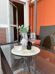 dos copas de vino y un jarrón en una mesa en Large comfortable 3 bedroom apartment, en Ugljan