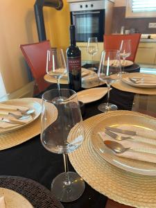 una mesa con copas de vino y una botella de vino en Large comfortable 3 bedroom apartment, en Ugljan