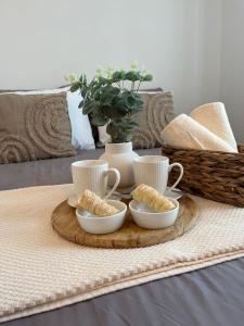 una bandeja con tres tazas y aperitivos en una mesa en Large comfortable 3 bedroom apartment, en Ugljan