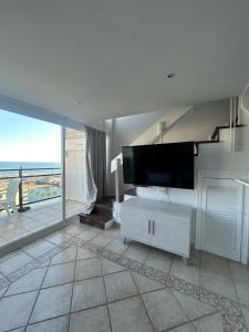 - un salon avec une télévision et une grande fenêtre dans l'établissement Skol 925A by Completely Marbella, à Marbella