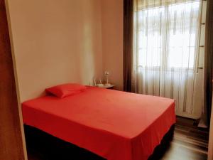 un letto rosso in una stanza con finestra di Cosy 3 bedroom apartment a Flic-en-Flac