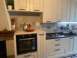 a kitchen with white cabinets and a stove top oven at Grazioso appartamento in Pieve Santo Stefano