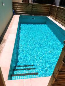 piscina con acqua blu e scale di Cosy 3 bedroom apartment a Flic-en-Flac
