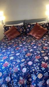 Una cama con un edredón y almohadas con motivos florales azules. en Grazioso appartamento, en Pieve Santo Stefano