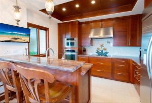 a kitchen with a large island with wooden cabinets at 1412 Ridge in Kahana