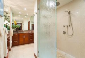 a bathroom with a shower with a glass door at 1412 Ridge in Kahana