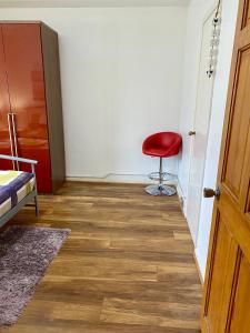 a room with a red chair and a door at 3 Bedroom House-Garden-Stratford-Olympic Park in London
