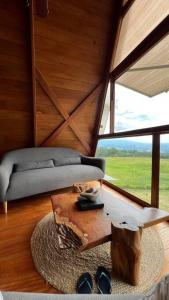 um quarto com um sofá, uma mesa e uma janela em Vista panorámica de Laguna Azul en Sauce-San Martín em Sauce
