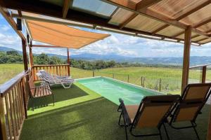 una terraza con sillas y una piscina en una casa en Vista panorámica de Laguna Azul en Sauce-San Martín, en Sauce