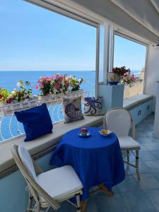 un tavolo e sedie su un balcone con vista sull'oceano di Palazzo Talamo a Positano