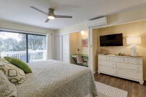 1 dormitorio con 1 cama y TV de pantalla plana en Townhouse Manor 20, en Hilton Head Island