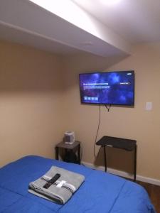 a bedroom with a bed with a flat screen tv on the wall at Willoughby in Newark