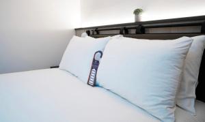 un montón de almohadas encima de una cama en Southgate Hotel London en East Barnet