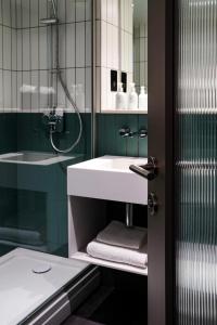 ein Bad mit einem Waschbecken und einer Dusche in der Unterkunft Southgate Hotel London in East Barnet